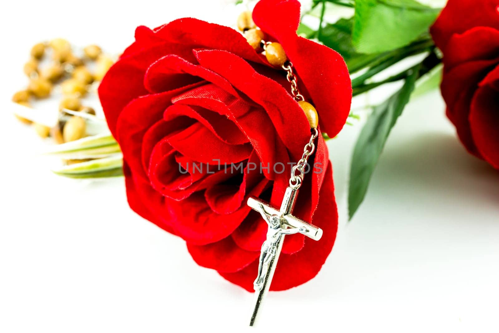 Rosary and rose on a white background