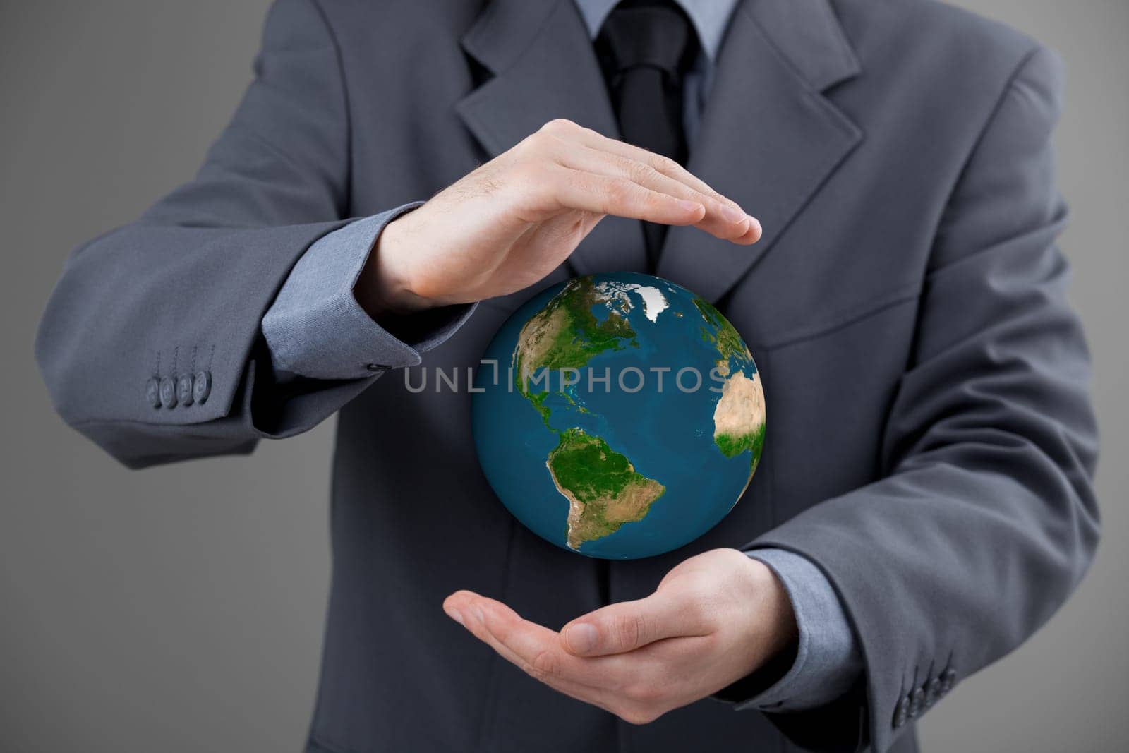 Business man protecting the Earth. Sustainable responsible business, eco-friendly business, global business concepts. Move heaven and earth idiom. Map texture by NASA.
