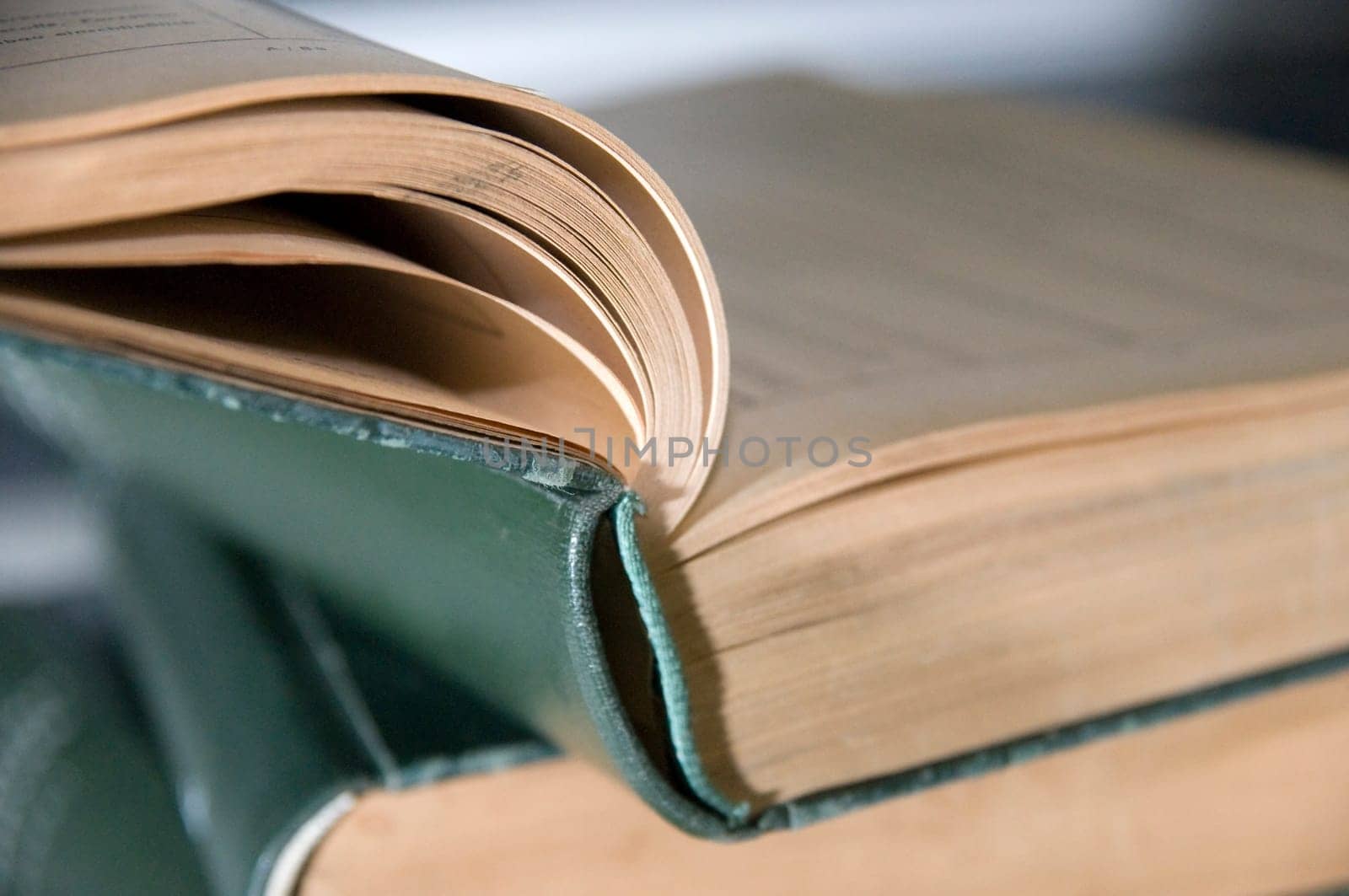 Close-up of a small stack of books of green bound old books  top book also struck
