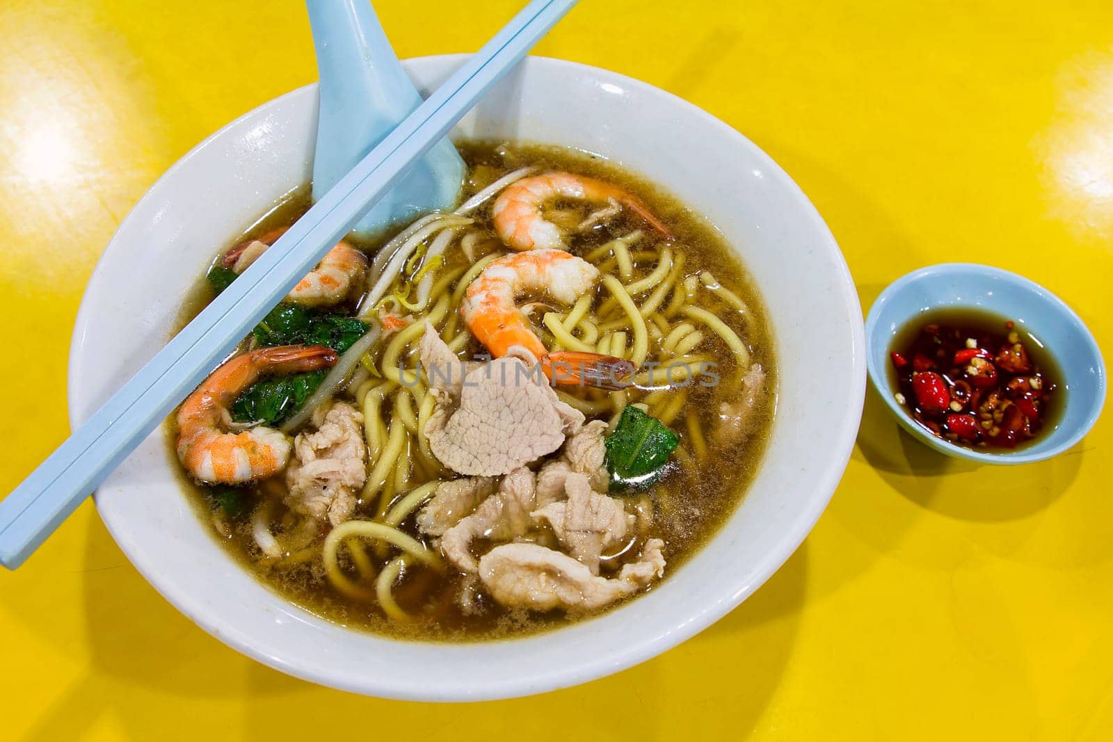 Hokkien Prawn Mee Soup Noodles with Pork and Vegetables and Side Dish of Cut Red Chili Peppers in Soy Sauce