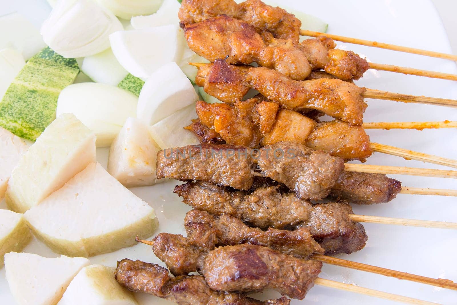 Mutton and Chicken Satay with Chopped Cucumbers Onions and Ketupat Rice Cake Macro