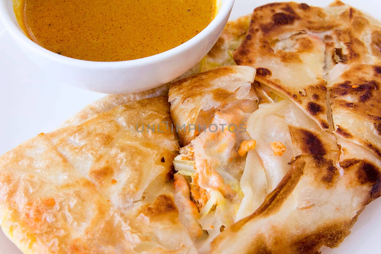 Indian Roti Prata with Chicken Meat and Curry Sauce Closeup