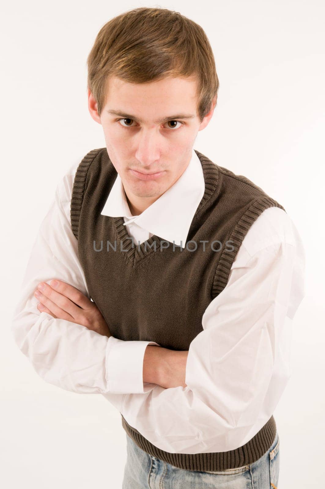 side torso shot of a young man in a white shirt and brown westover with crossed arms  Looking at the camera