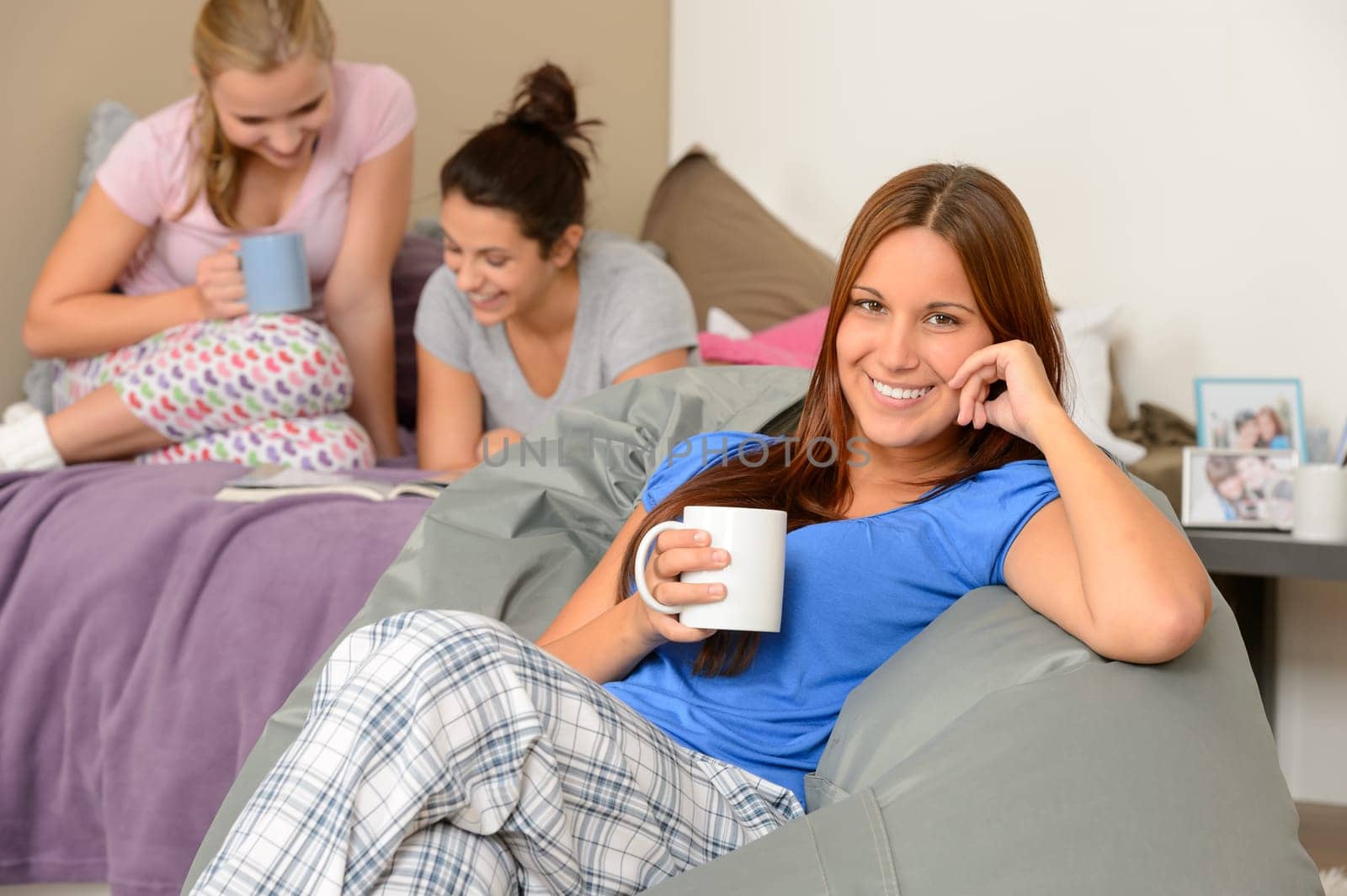 Teenager girls reading and drinking at slumber party