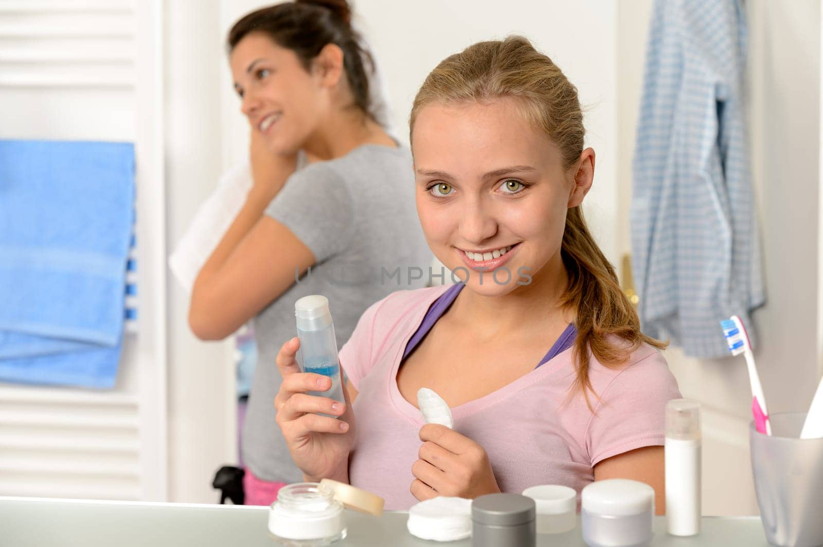 Two young women sisters getting ready in the bathroom