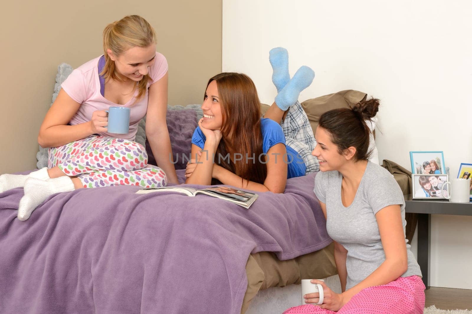 Three teenage girls talking at pajama party in bedroom