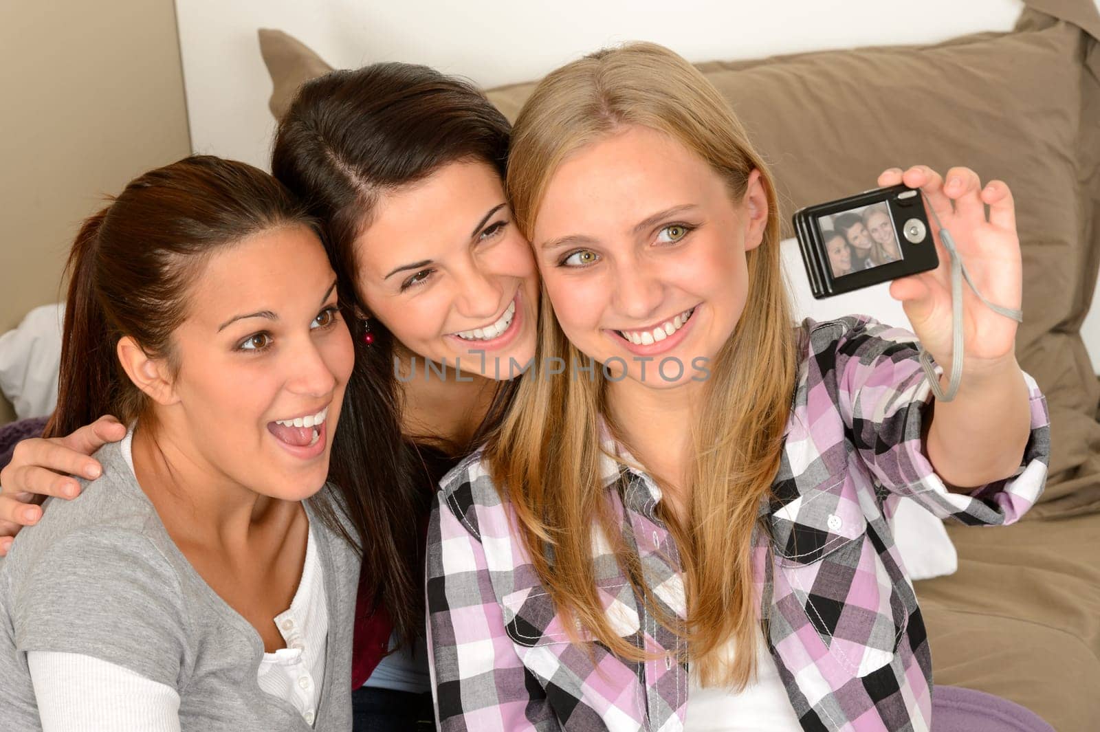 Smiling young girls taking self portrait at home