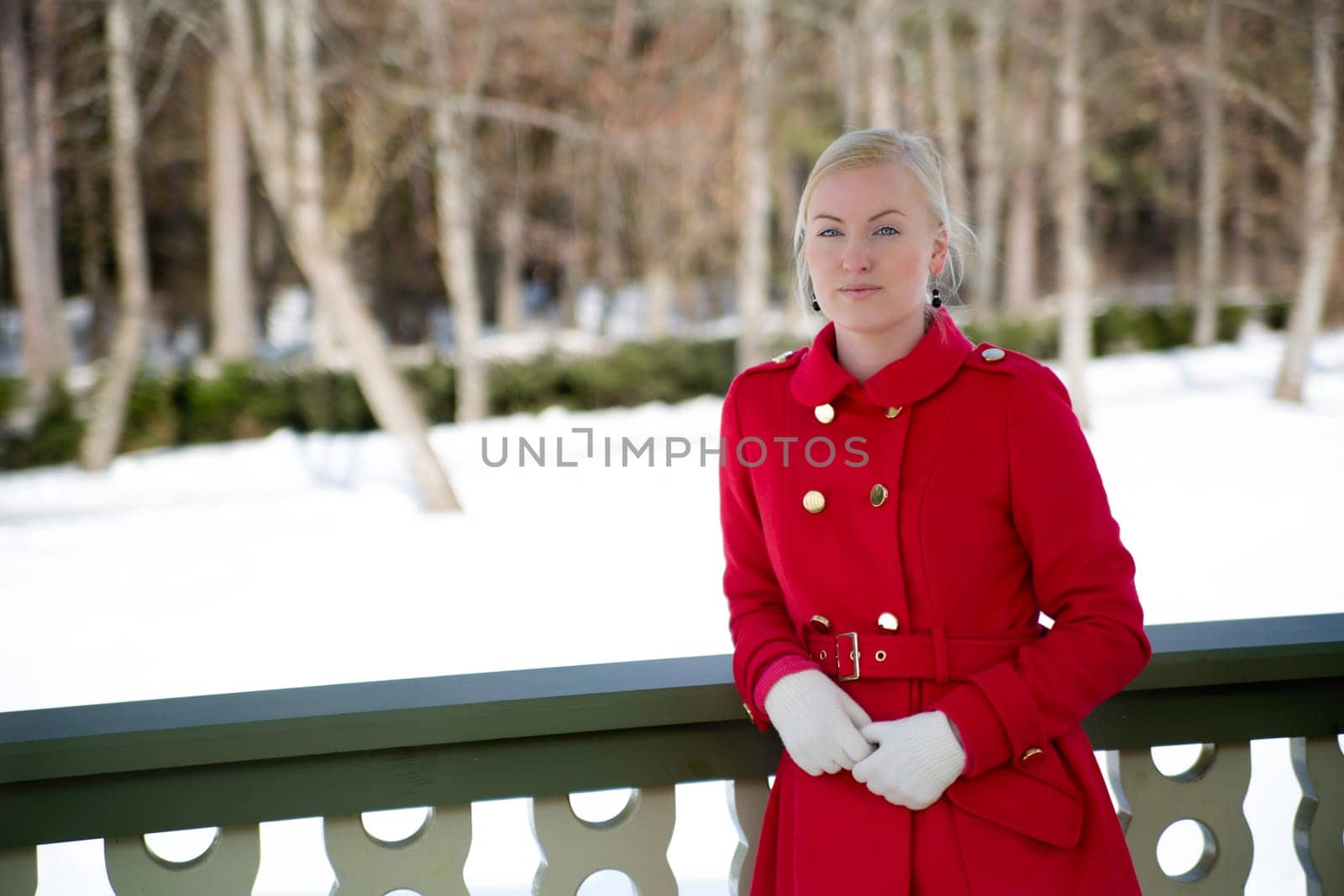 Young woman in red coat at wooden terrace