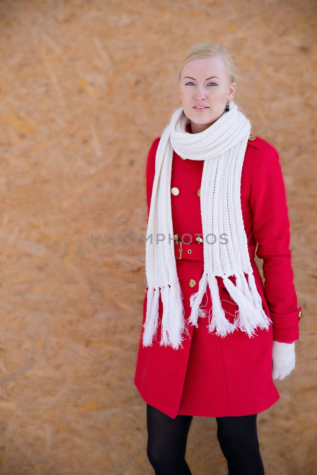 Young woman posing on camera on smooth wall