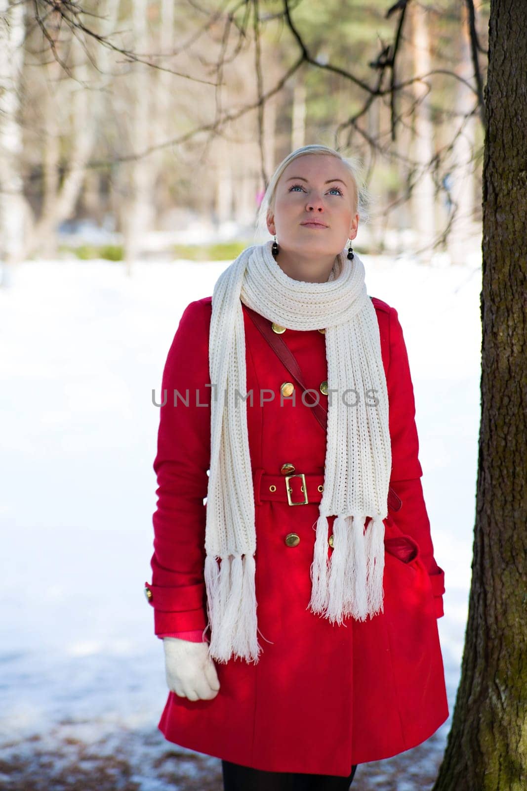 Young woman posing under spruce at winter day