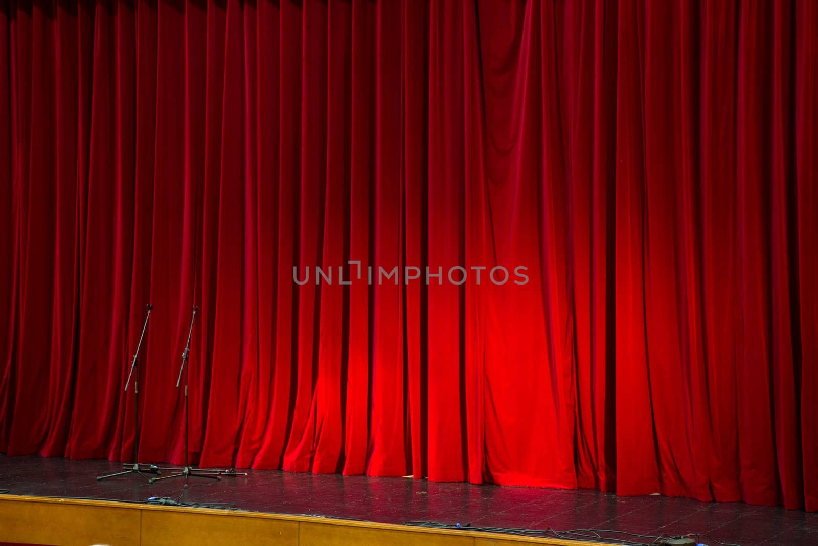 Lighted up red stage curtain and wait performer