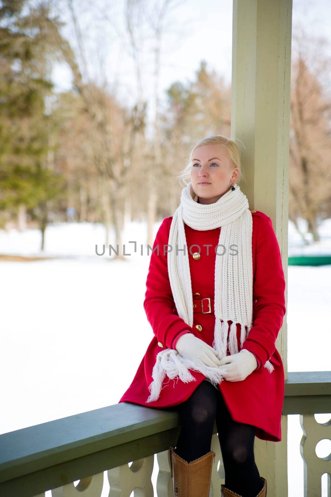 Woman in red coat dreaming at terrace boundary