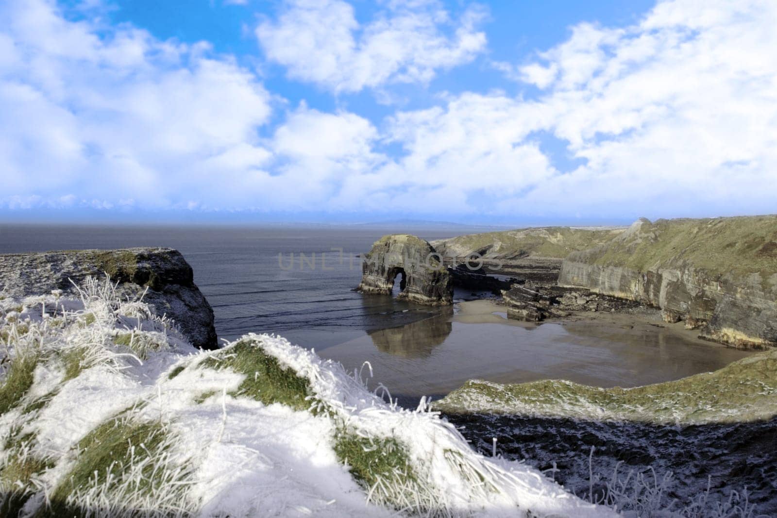 snow covered view of beach cliffs and the virgin rock in ballybunion county kerry ireland