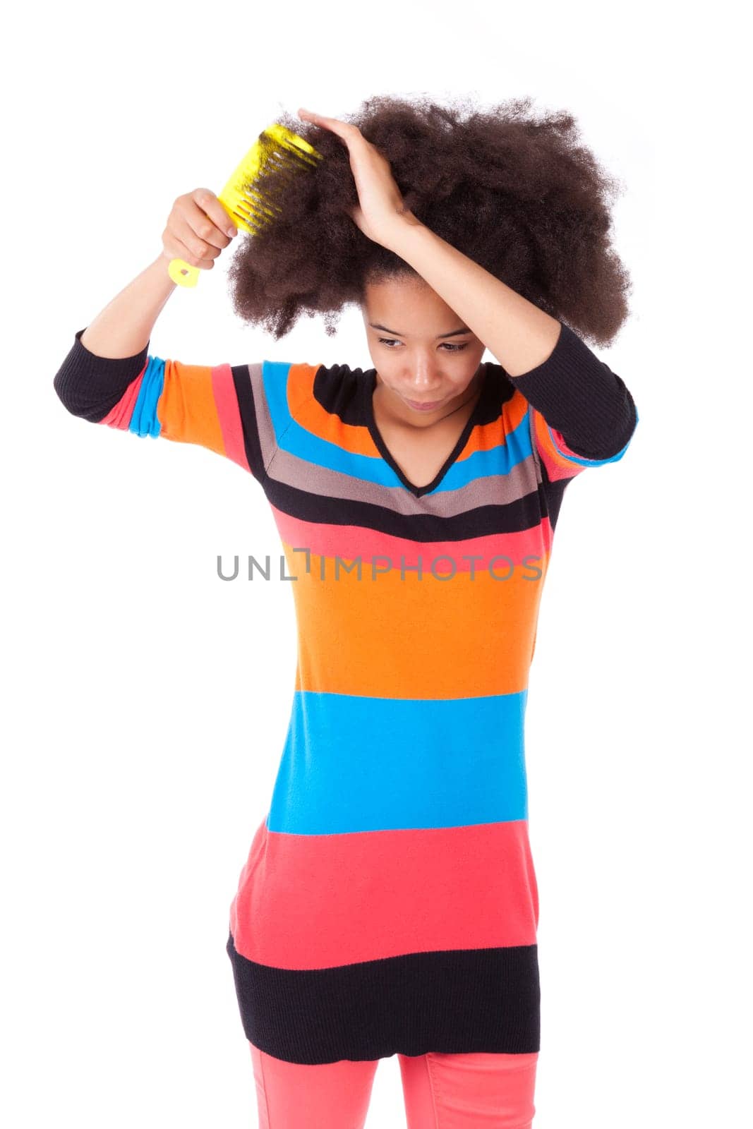 Black African American teenage girl combing her afro hair, isolated on white background