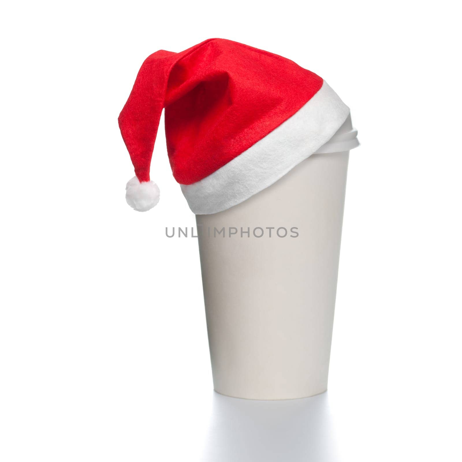 White paper coffee cup with plastic cap on top. Blank space for copy on cup and besides. Red santa christmas hat on top of the cup. Square format.