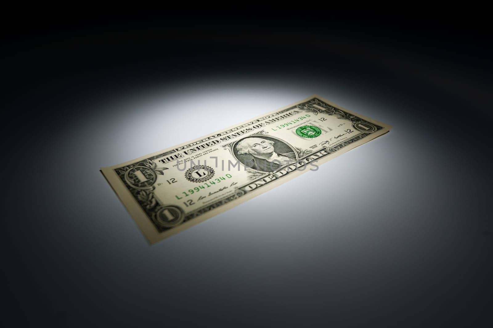 United states one dollar bank note on dark background under spot light