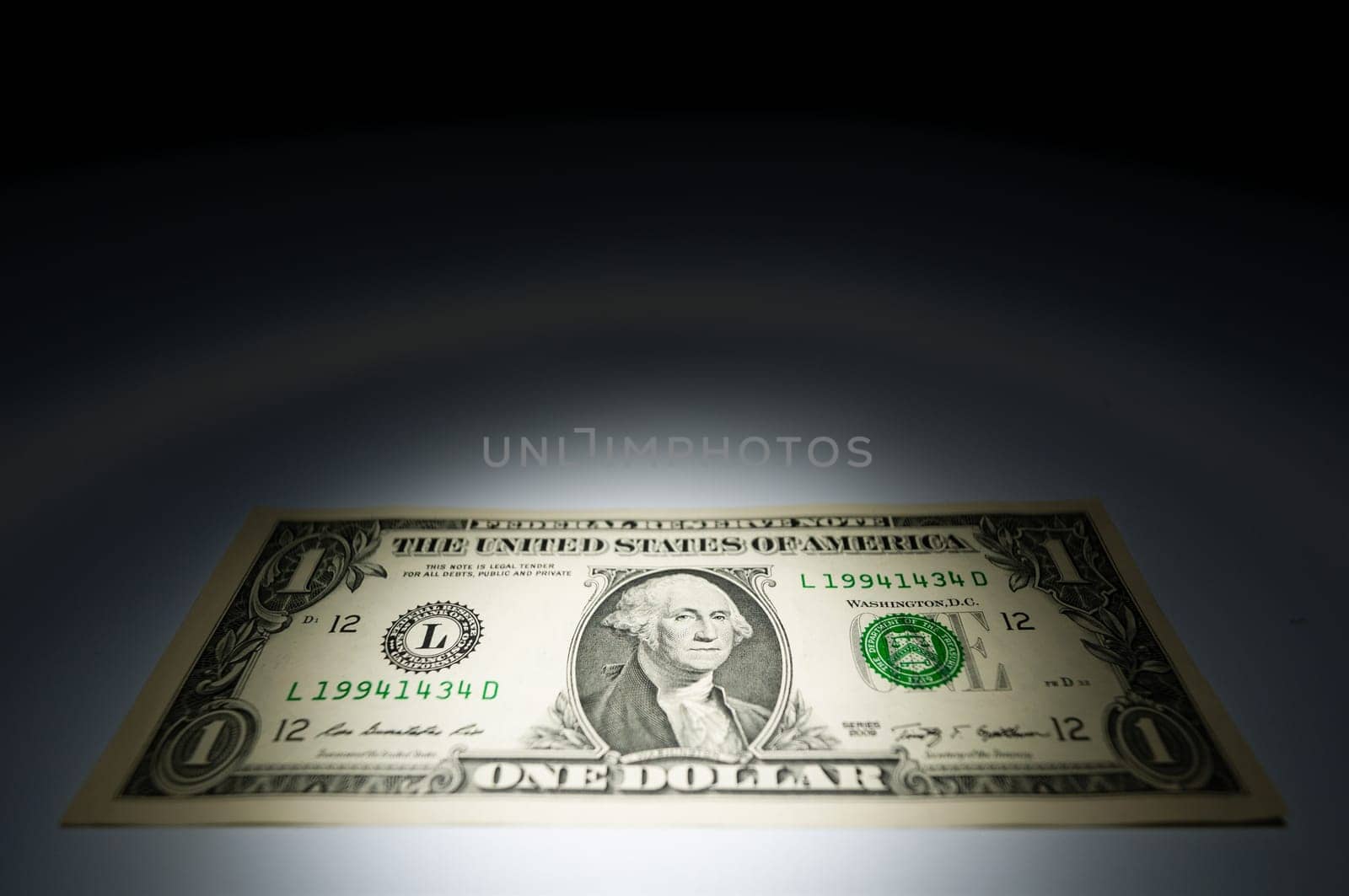 United states one dollar bank note on dark background under spot light