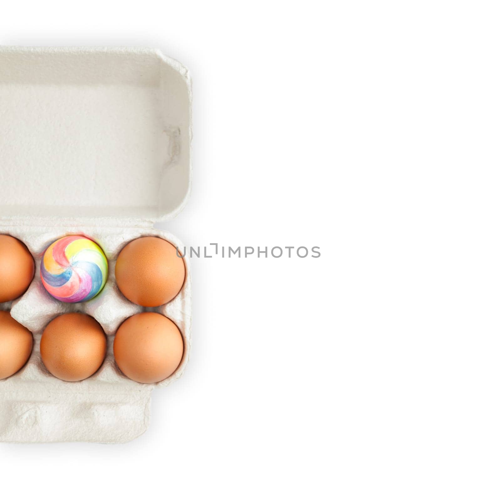 colorful painted easter egg in crate with ordinary eggs.  Isolated on white background. A lot of copy space.