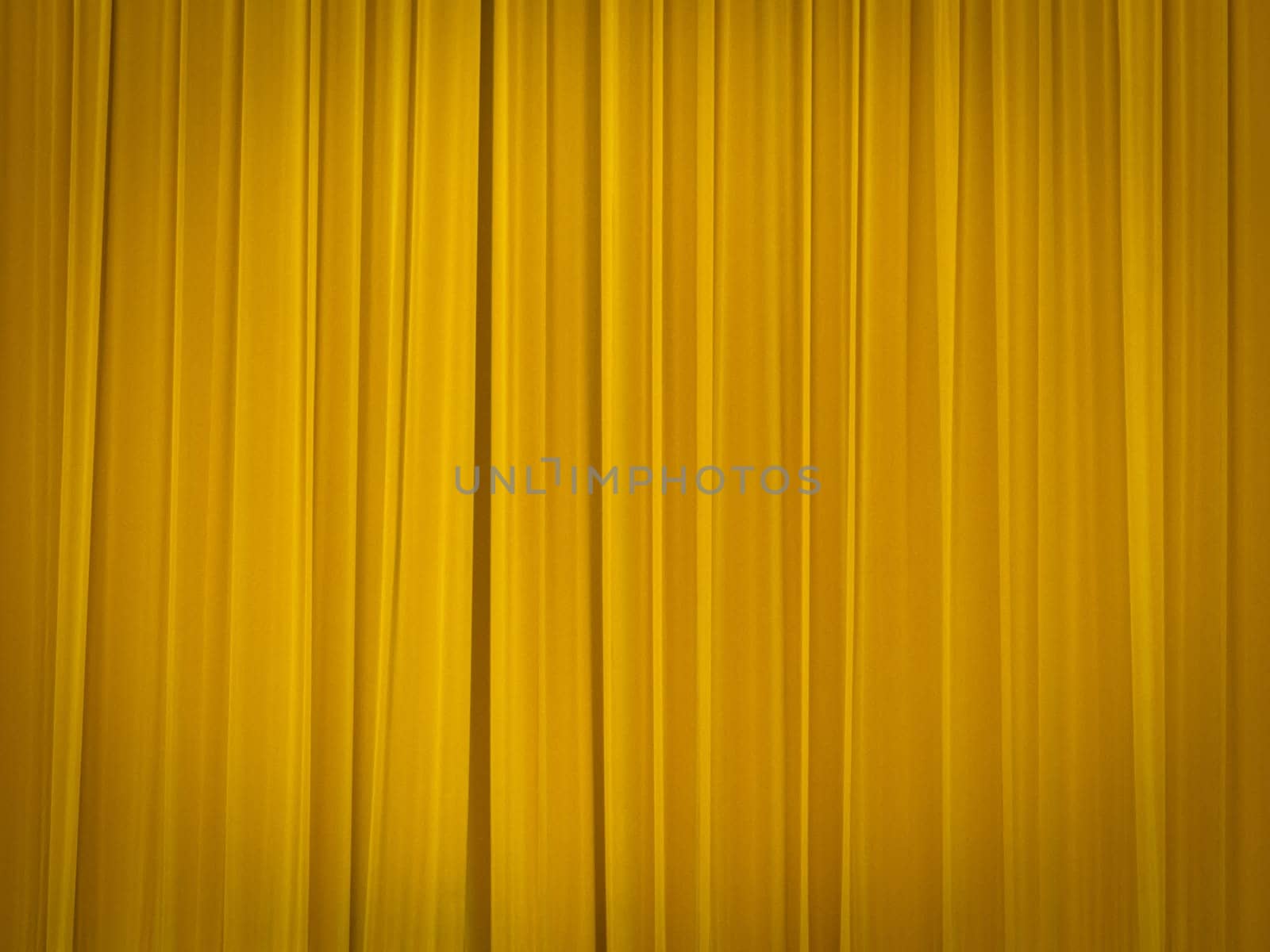 stage of the theatre with yellow curtains closed
