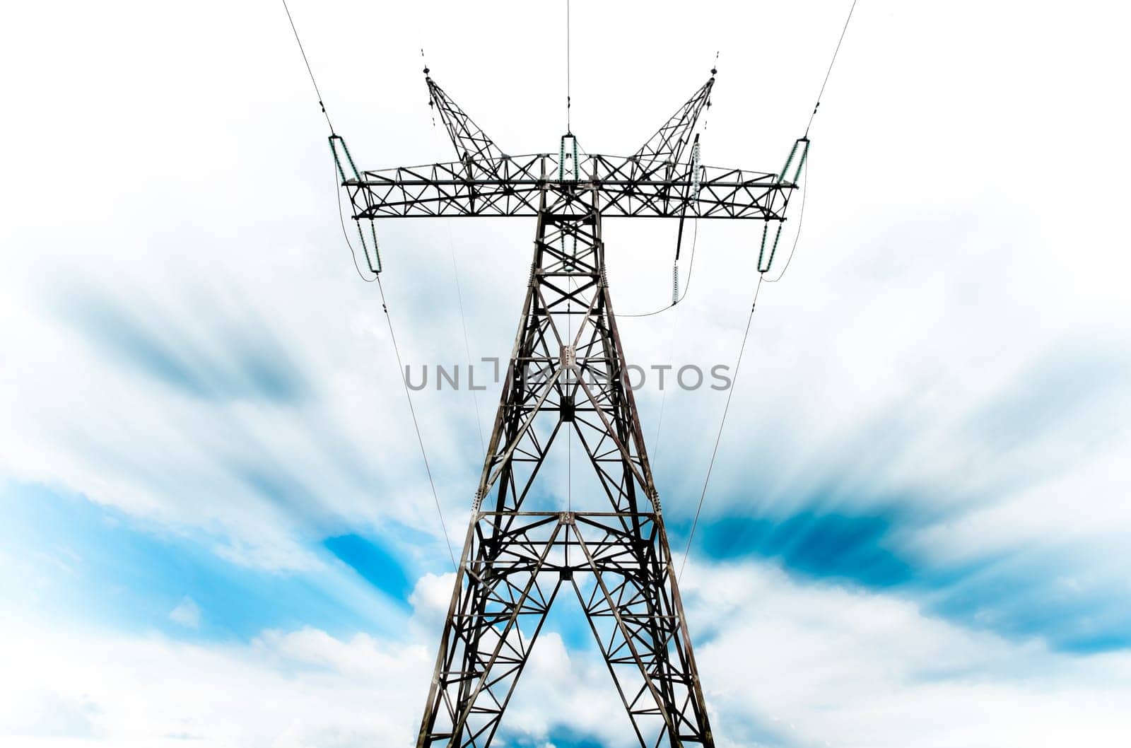power grid pylon against blue cloudy sky with visible motion blur