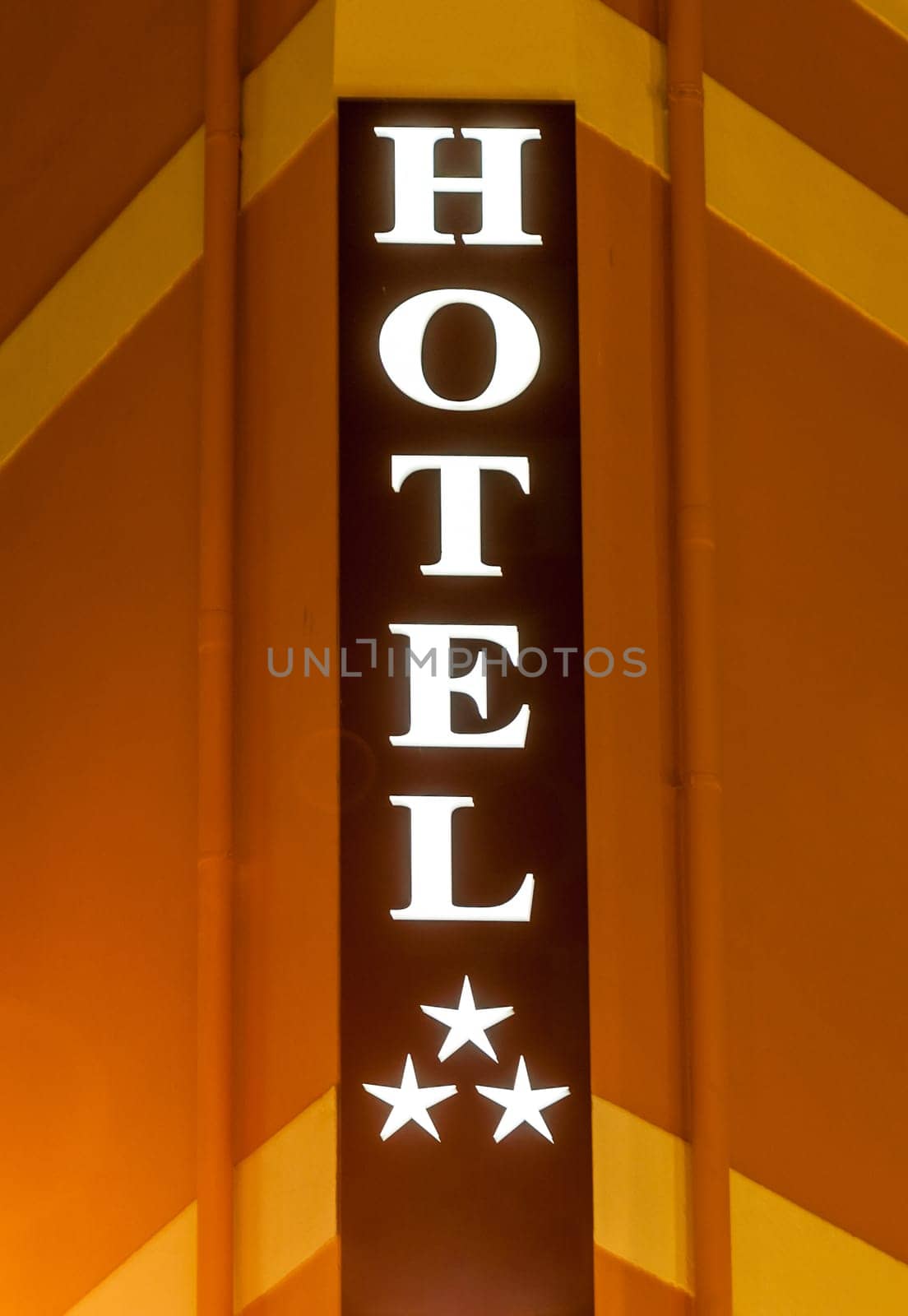 Illuminated hotel sign on building at night
