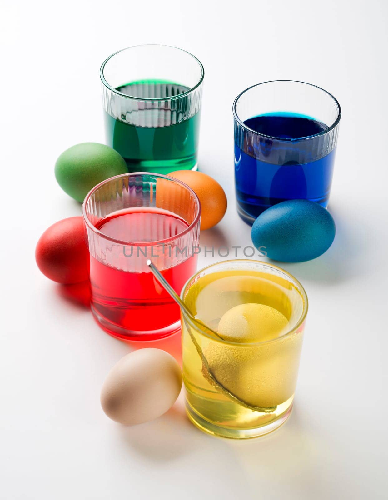 Easter eggs dyeing in glass with colors