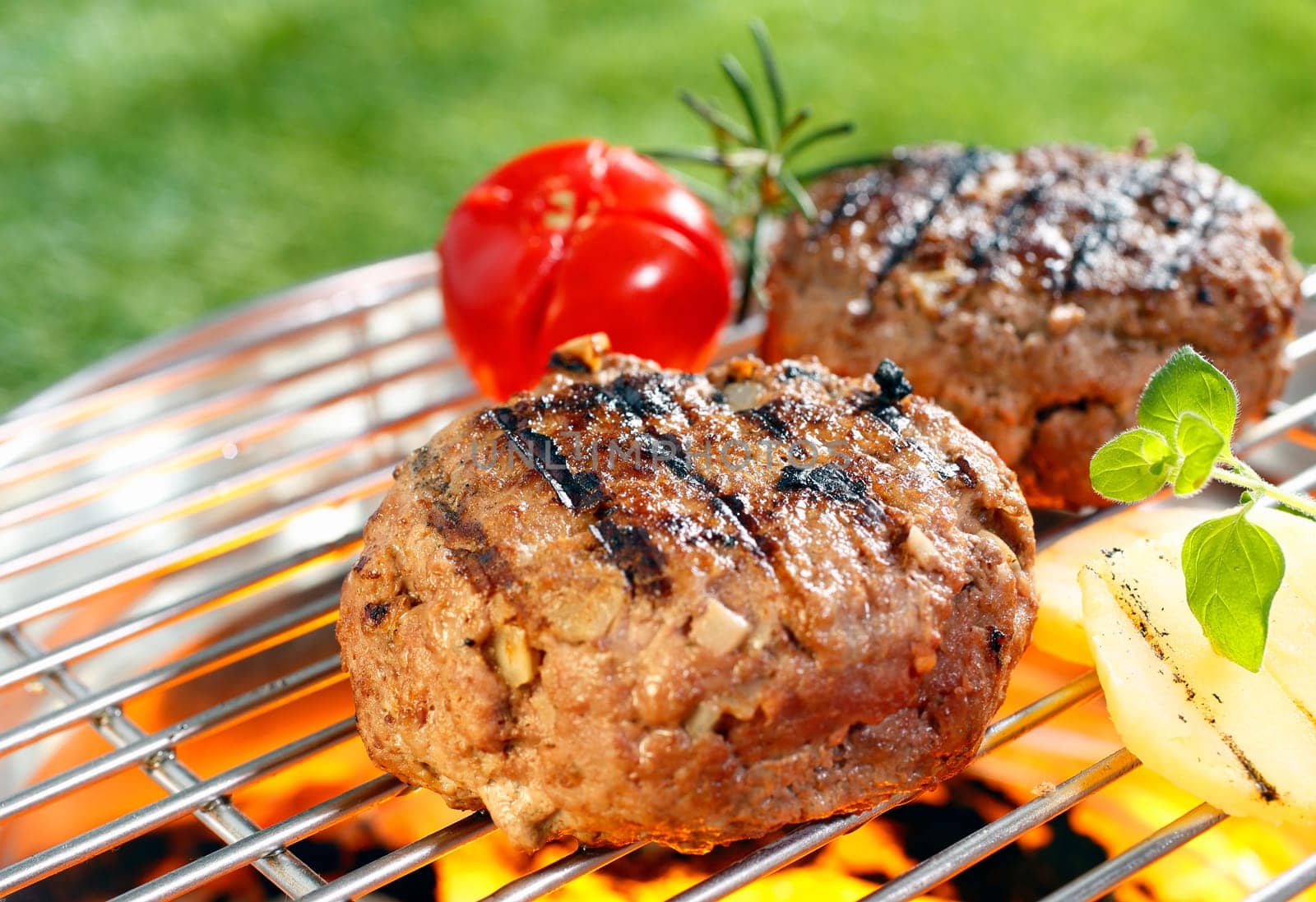 Beef burgers cooking on grilling pan outdoors