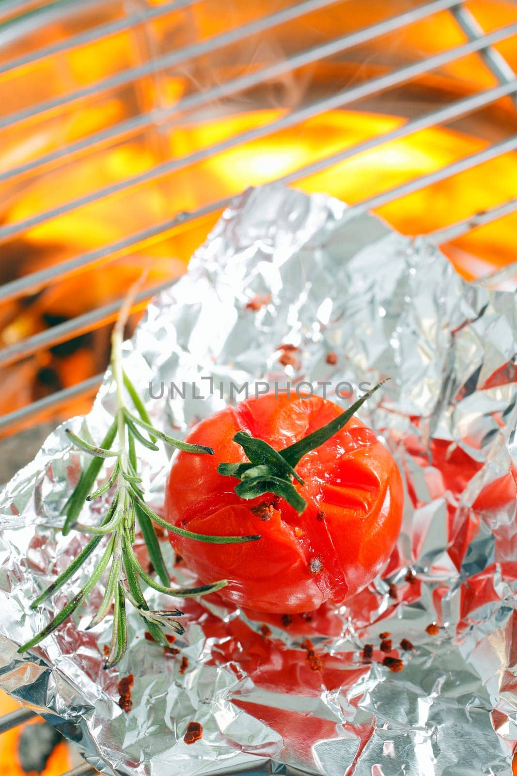 Grilled tomato on aluminium foil on oven grill
