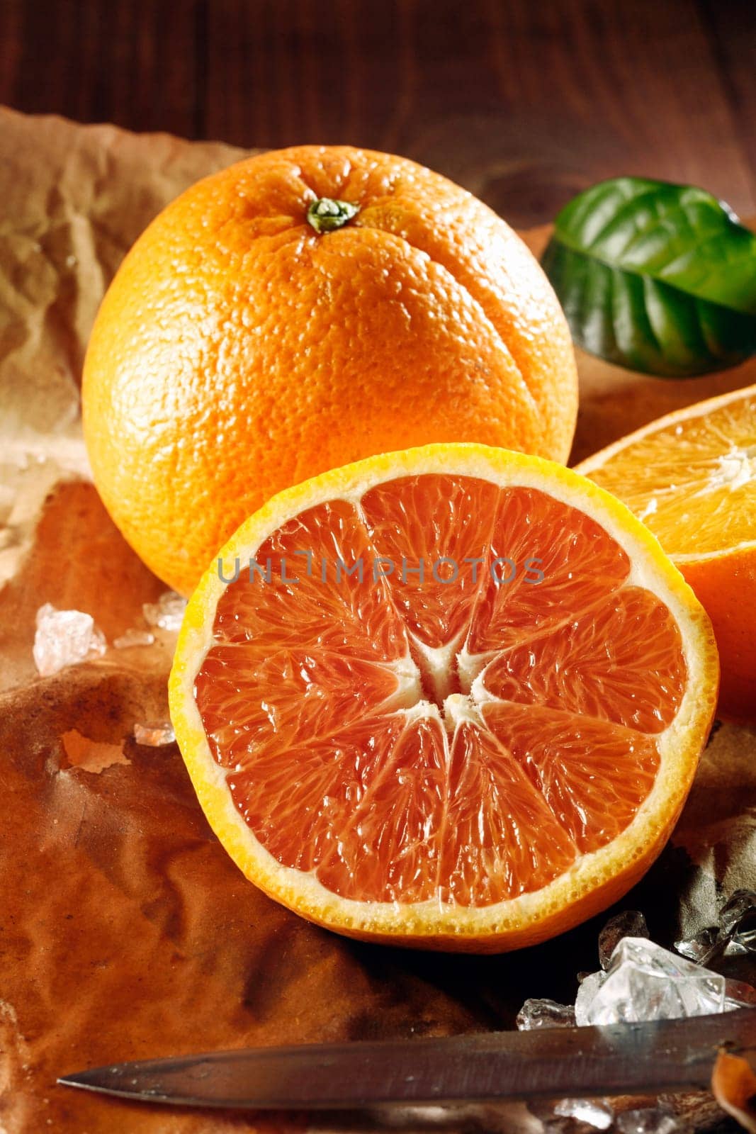 Two juicy oranges, one sliced in halves