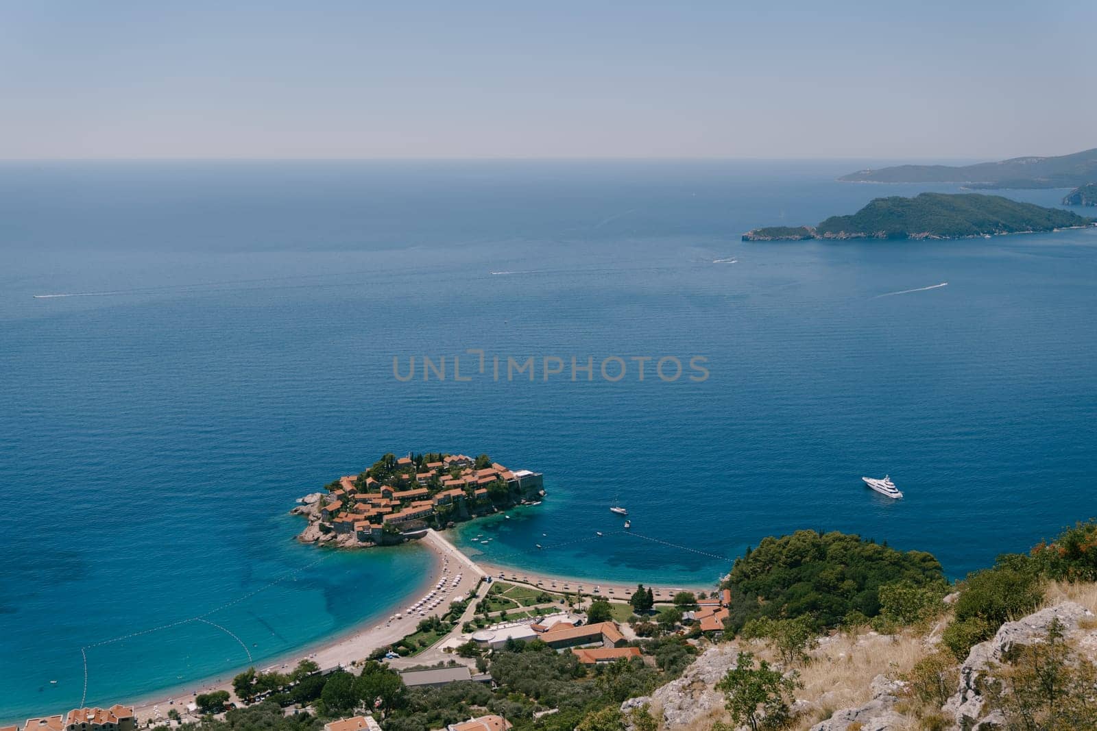 Isthmus of the island of Sveti Stefan with a beach. Montenegro by Nadtochiy