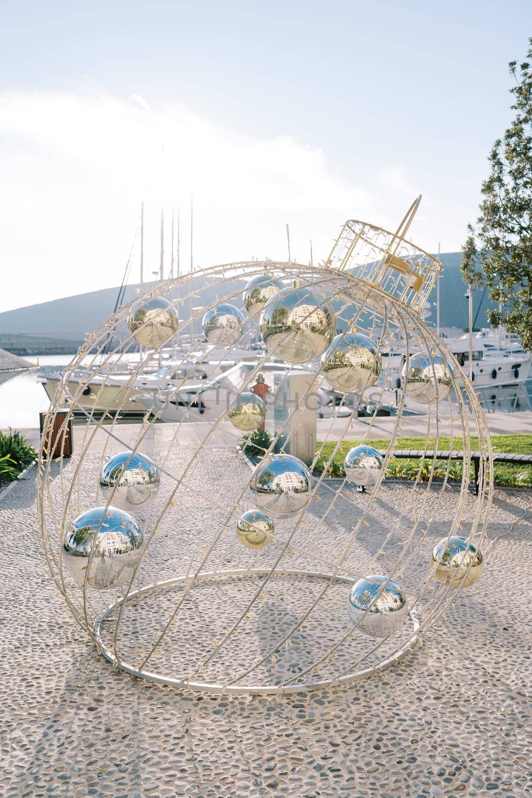 Christmas installation in the form of a Christmas ball with garlands stands on the pier by Nadtochiy