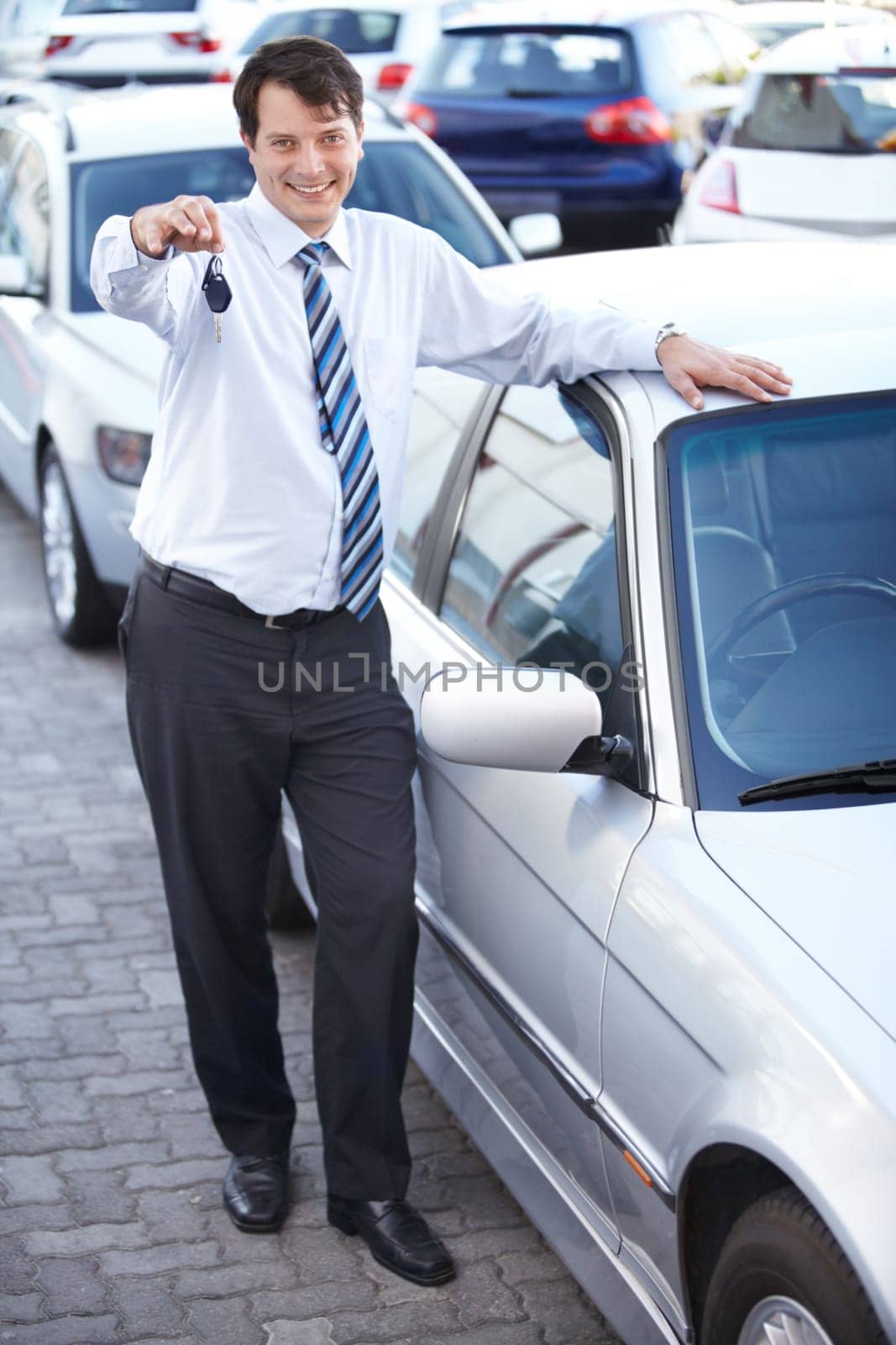 Businessman, portrait and key in hand to car with sale of auto, transportation and investment. Vehicle, dealership or man with keys in parking lot from salesman for test drive, opportunity or driving.