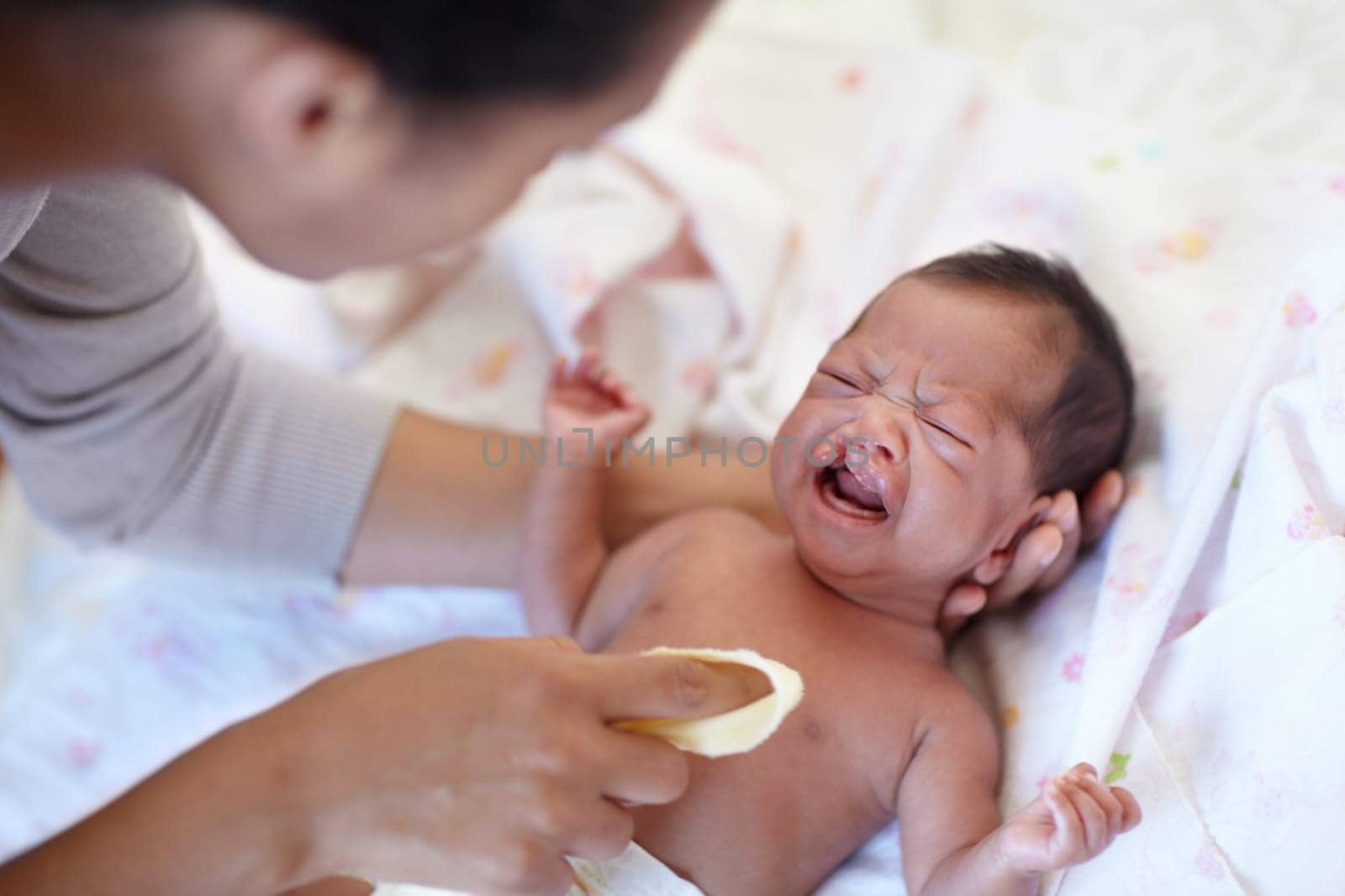 Newborn, crying and cleft palate with cleaning, mom and bed with parent, sick and frustrated. Medical issue, syndrome and home bedroom for healthcare, childcare and mouth for baby, pain and sadness.