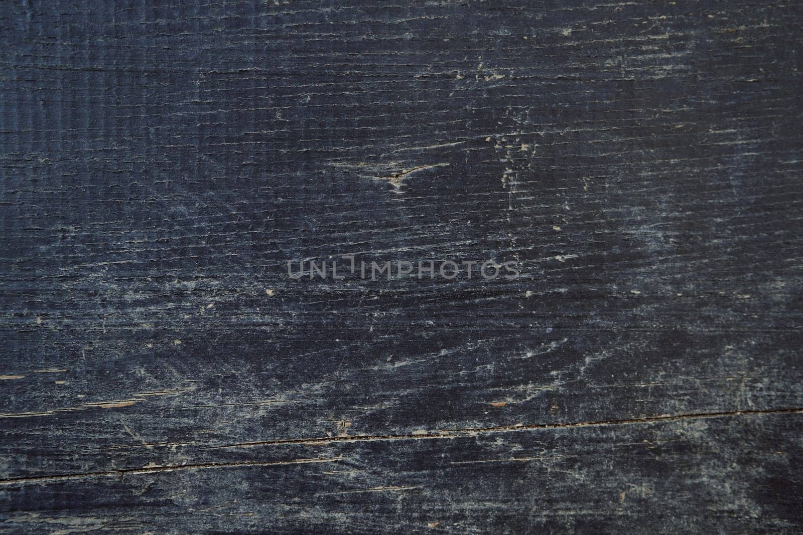 Dark wooden background with scratched paint and wood cracks by Nadtochiy