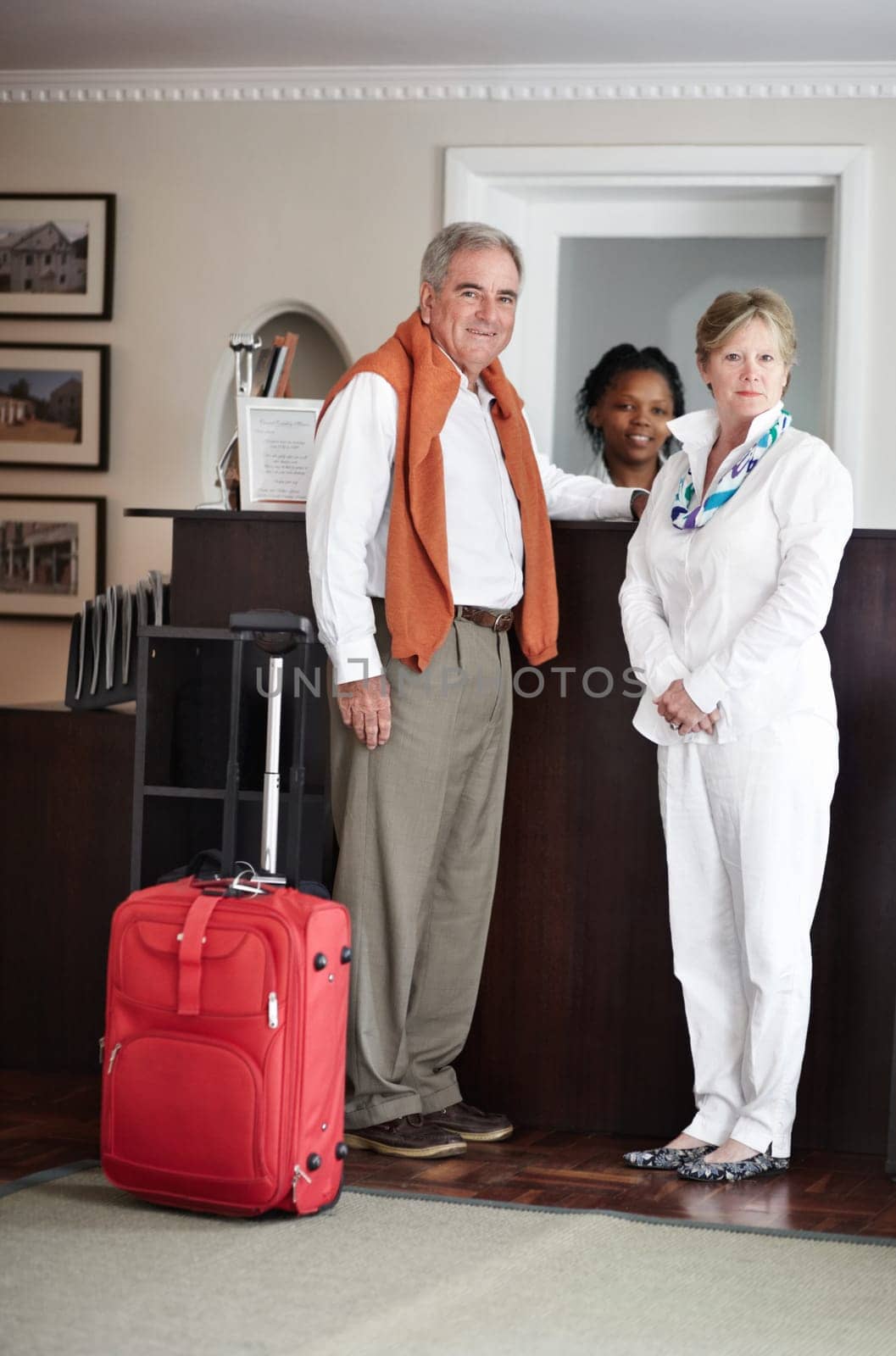 Travel, hotel and senior couple by reception to check in desk for love, anniversary and relax. Retirement, hospitality resort and elderly man and woman with concierge for bonding, holiday or vacation by YuriArcurs