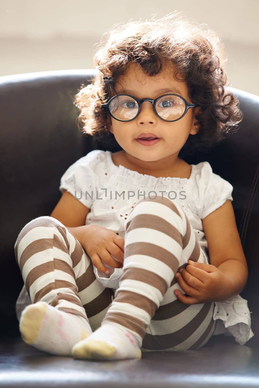 Toddler, girl and portrait or glasses for play, learning childhood development or education growth. Female person, kid or face eyewear on home relax sofa for intelligent, knowledge or nerd spectacles by YuriArcurs