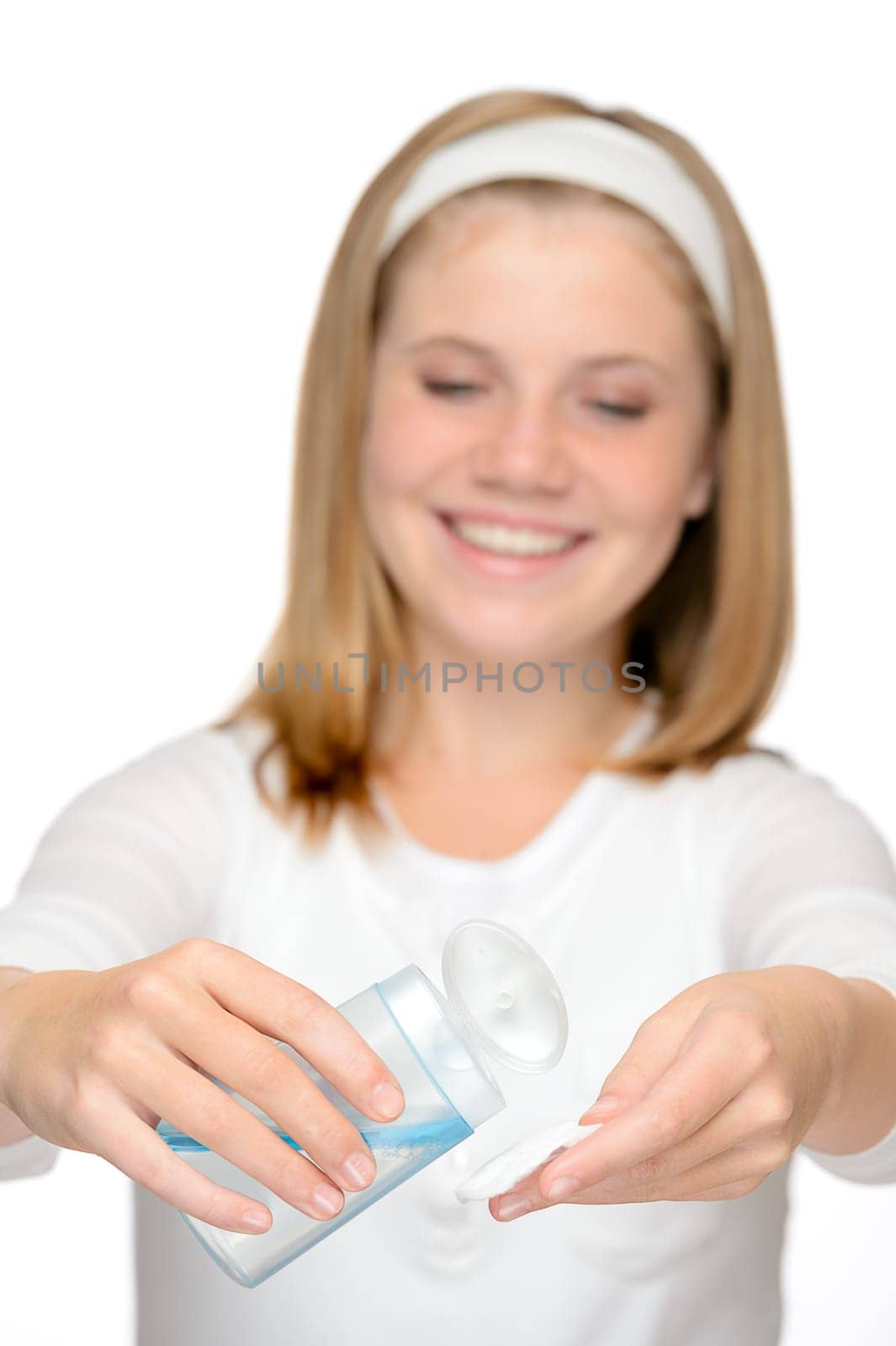 Young smiling girl applying face cleaning lotion make-up remover