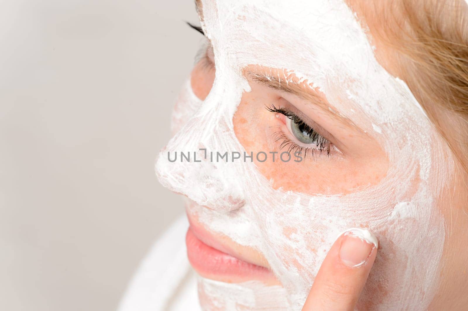 Cheerful teenager girl using face mask cleaning moisturizer hygiene