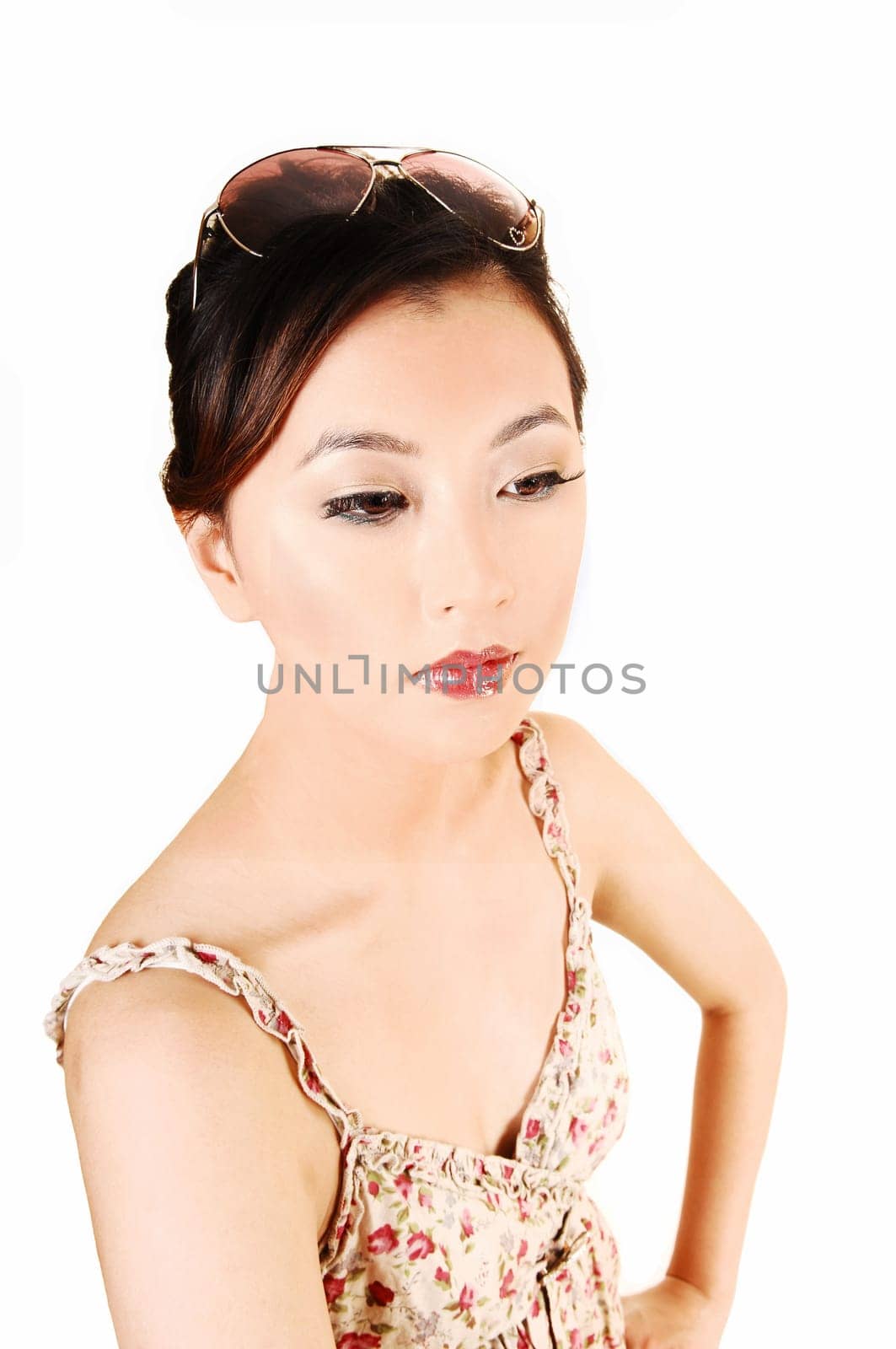 A closeup portrait of a beautiful chinese woman with sunglasses on her head and a light summer dress for white background.