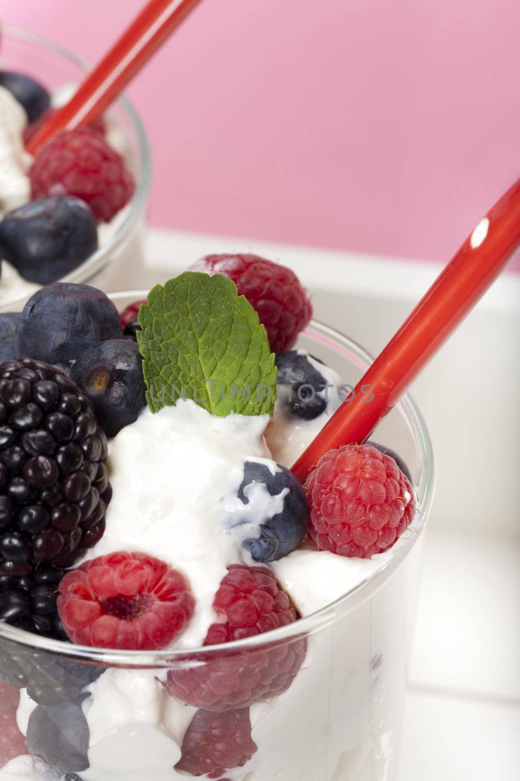 Yoghurt mousse dessert with colourful berries and mint leaves