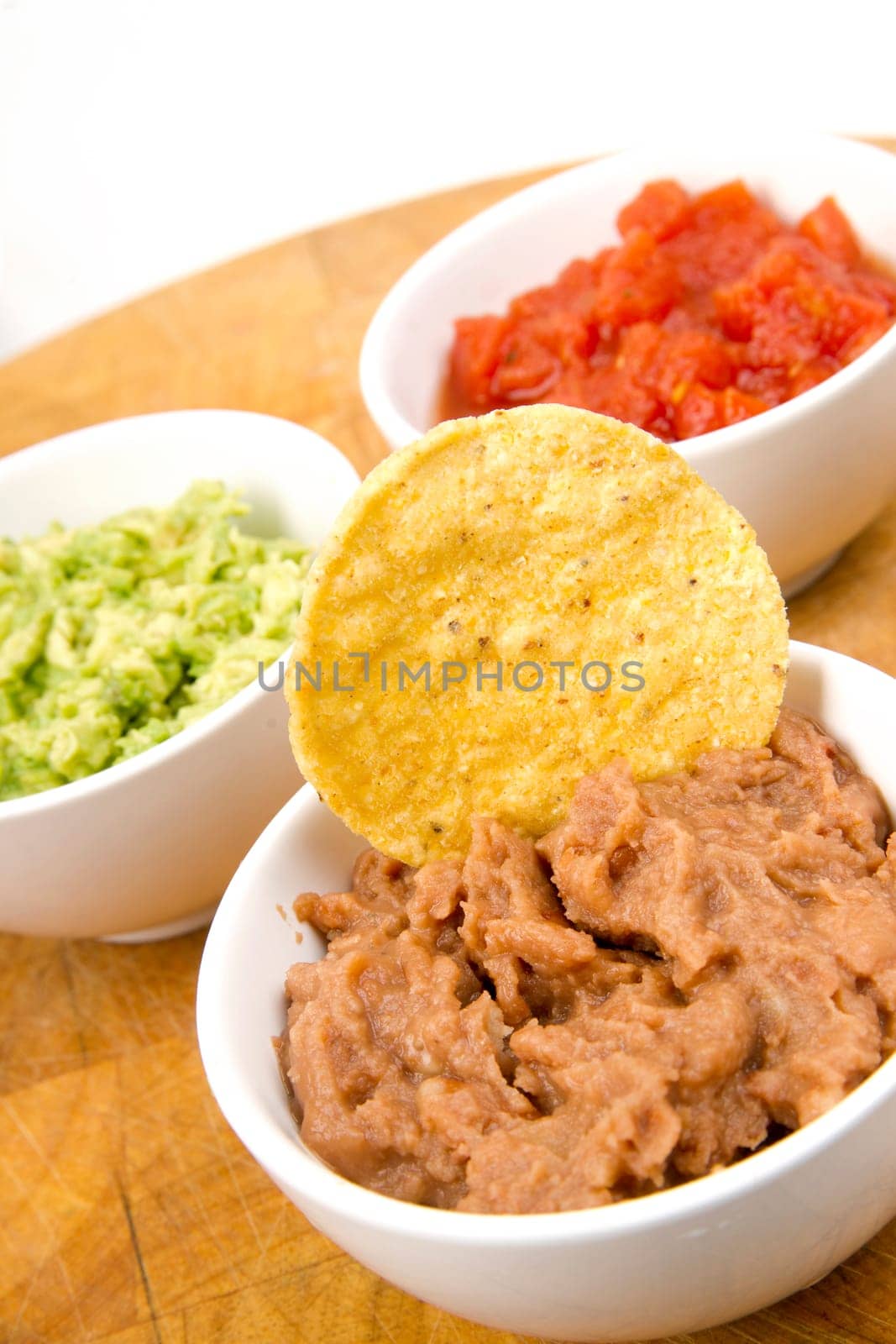 Food Appetizers Chips and Salsa Refried Beans Guacamole on Wood Cutting Board