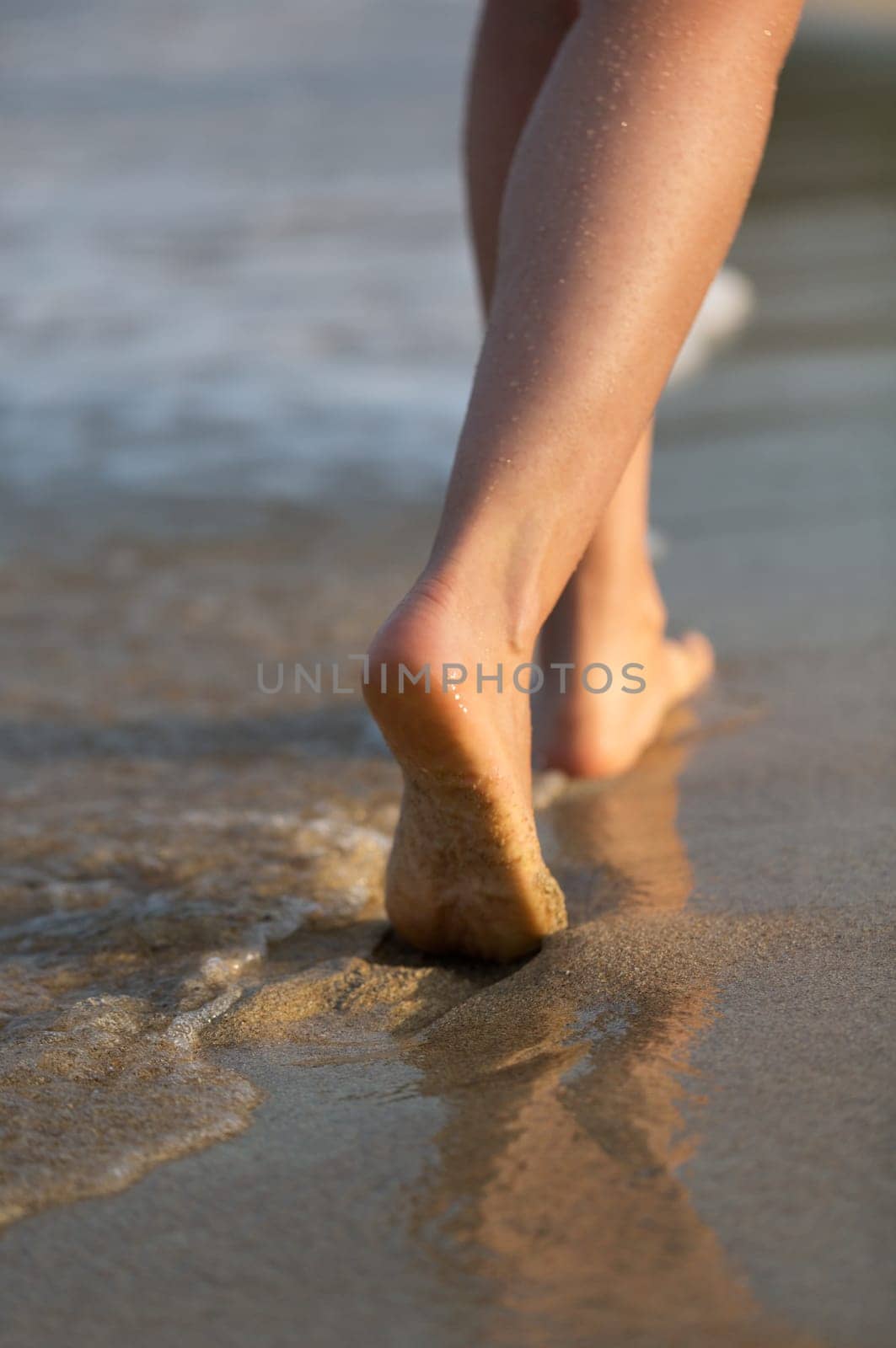 Human legs. Beautiful woman walking on the beach