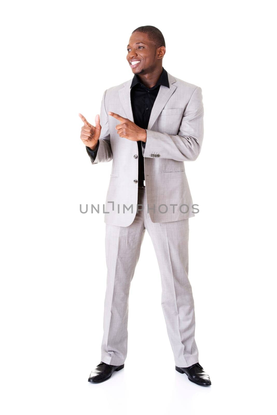 Happy successful businessman pointing on copy space. Isolated on white.