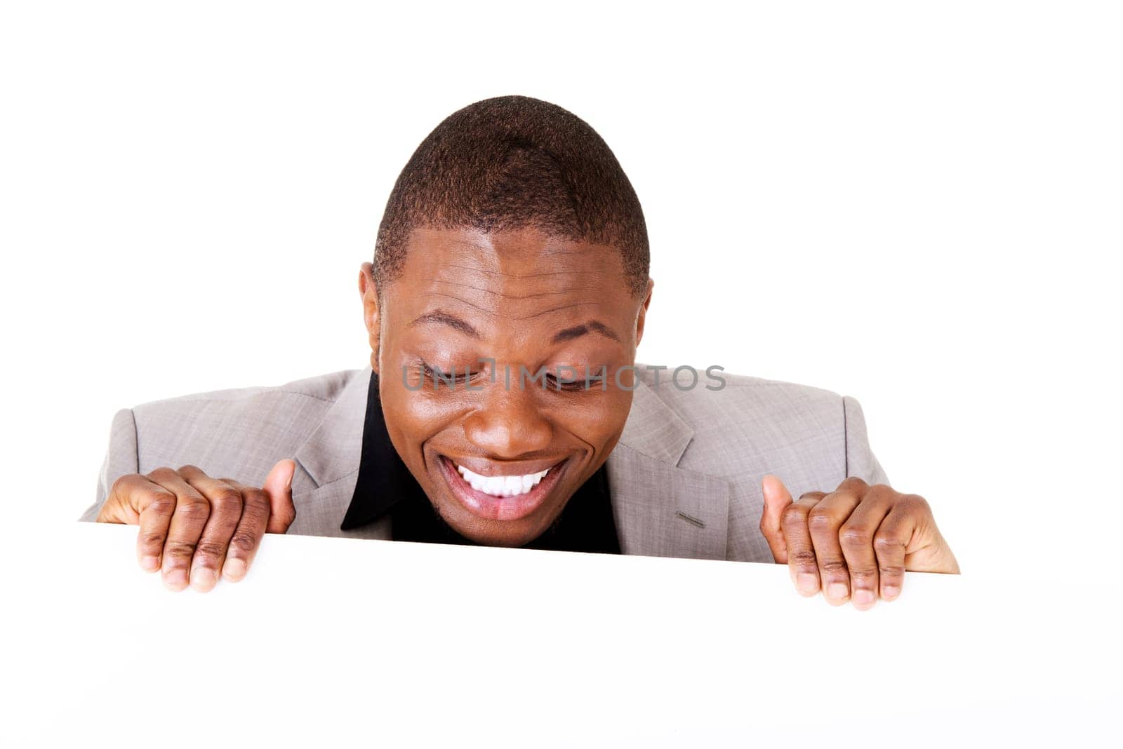 Happy successful businessman holding and showing blank advertisement. Isolated on white.