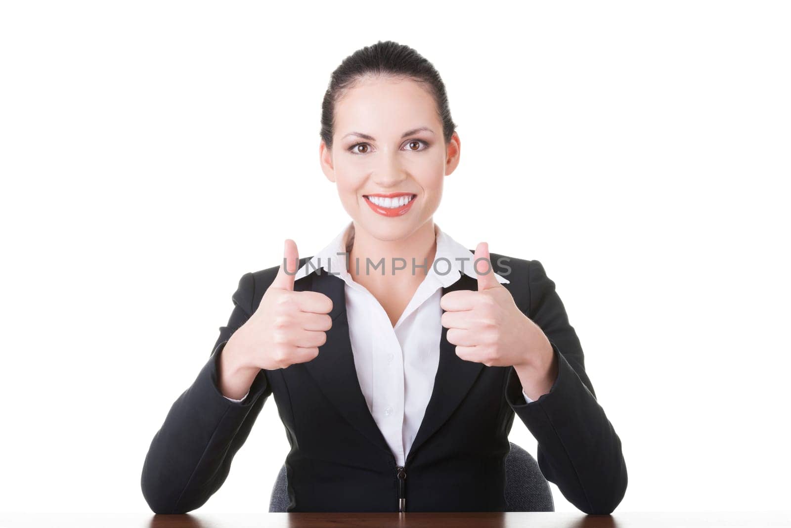 Young woman at the desk gesturing OK , isolated on white