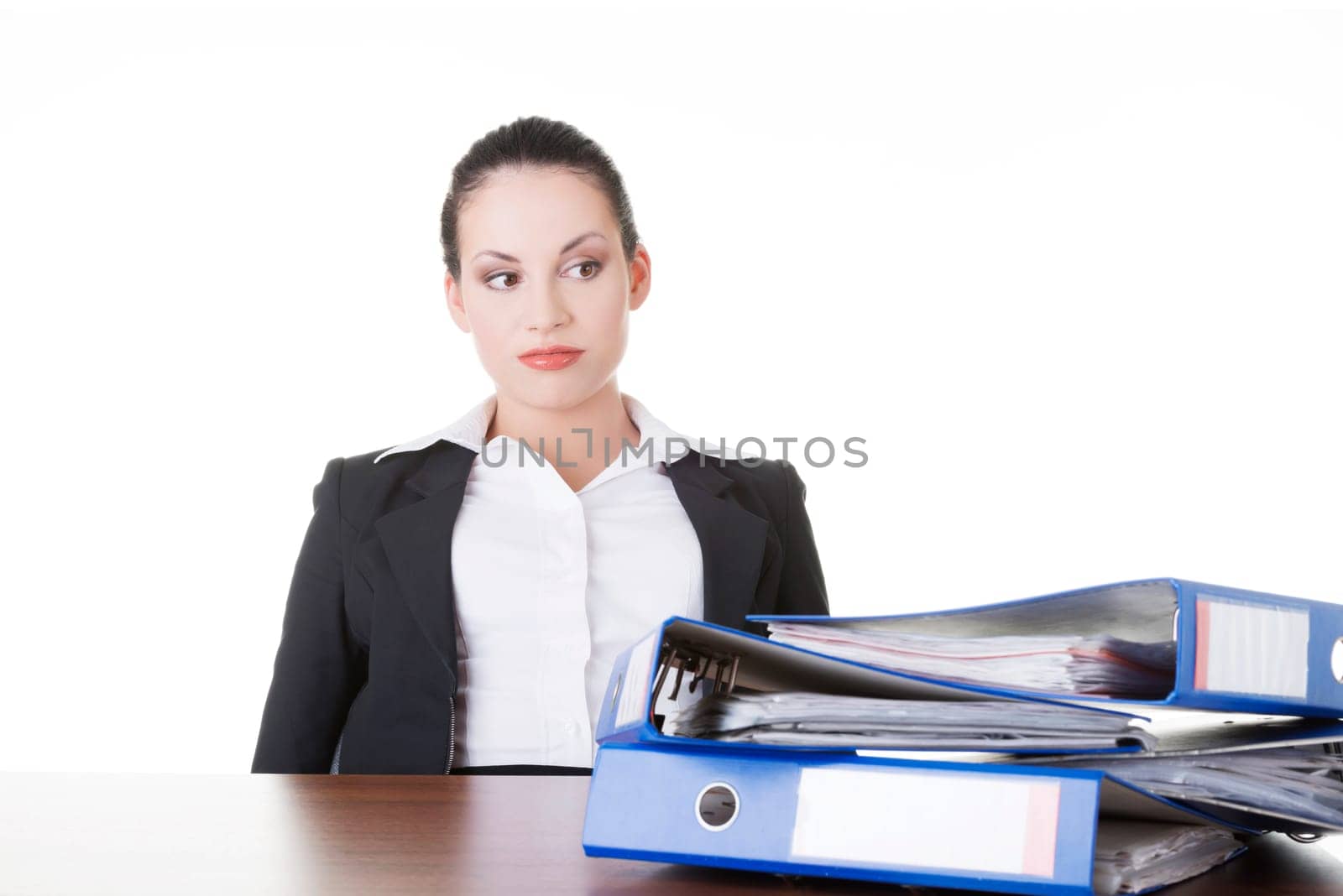 Sad woman with ringbinders sitting at the desk. Tired and exhousted business woman.