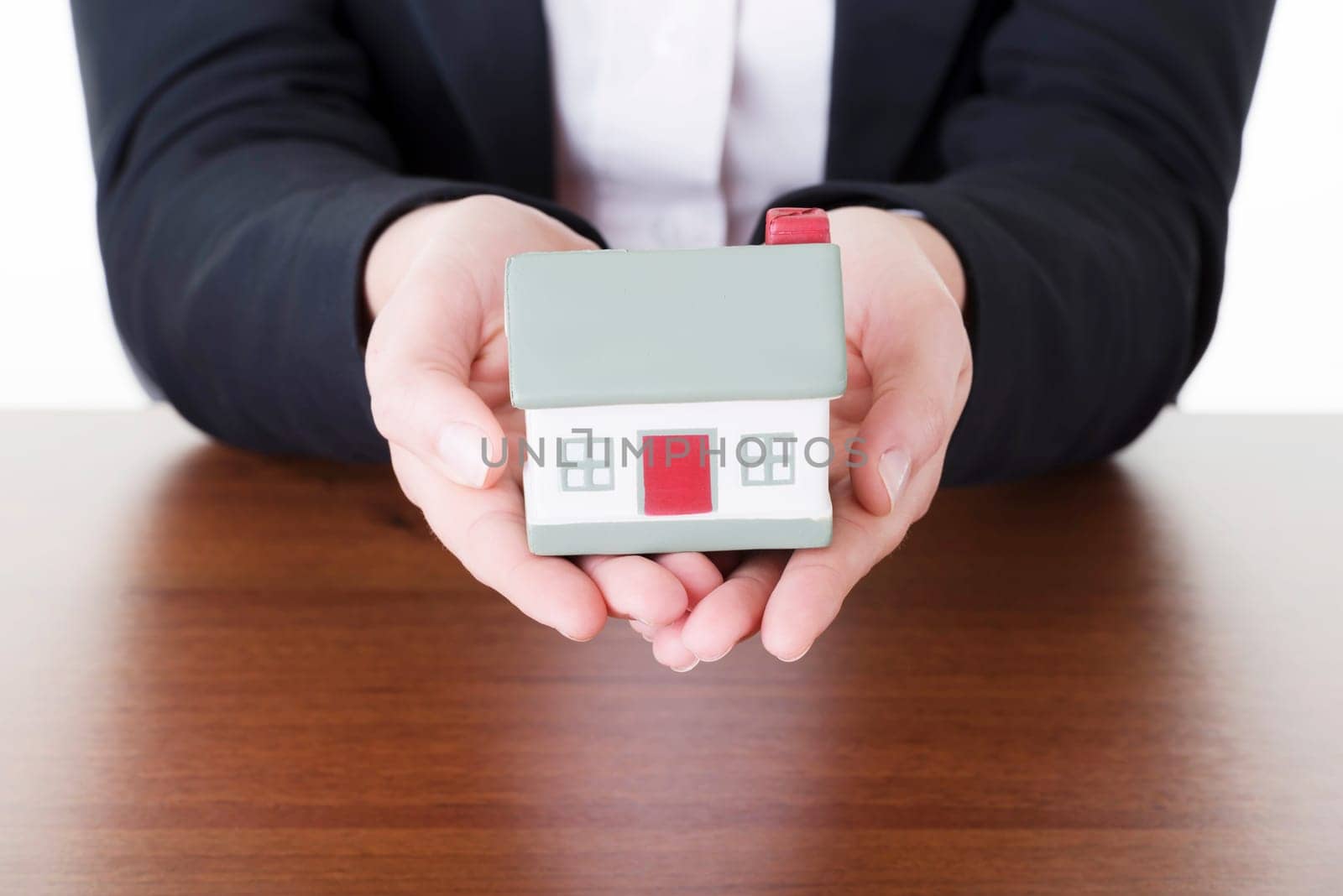 Businesswoman with house model over white - real estate loan concept