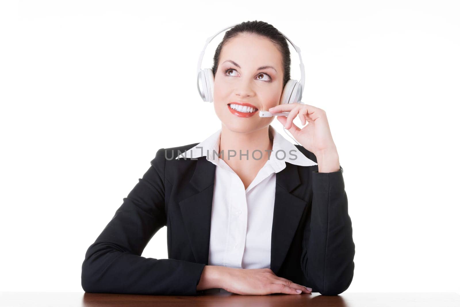 Beautiful young call-center assistant at the desk, isolated on white
