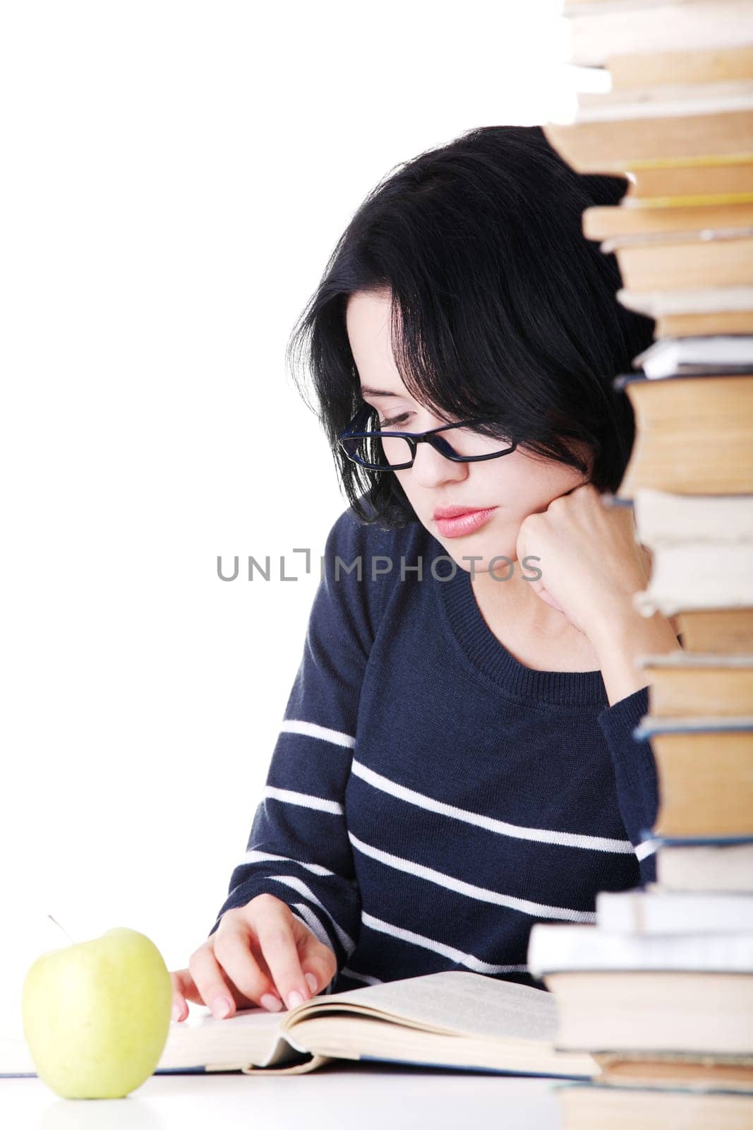 Young student woman with books studying at the desk, isolated on white background