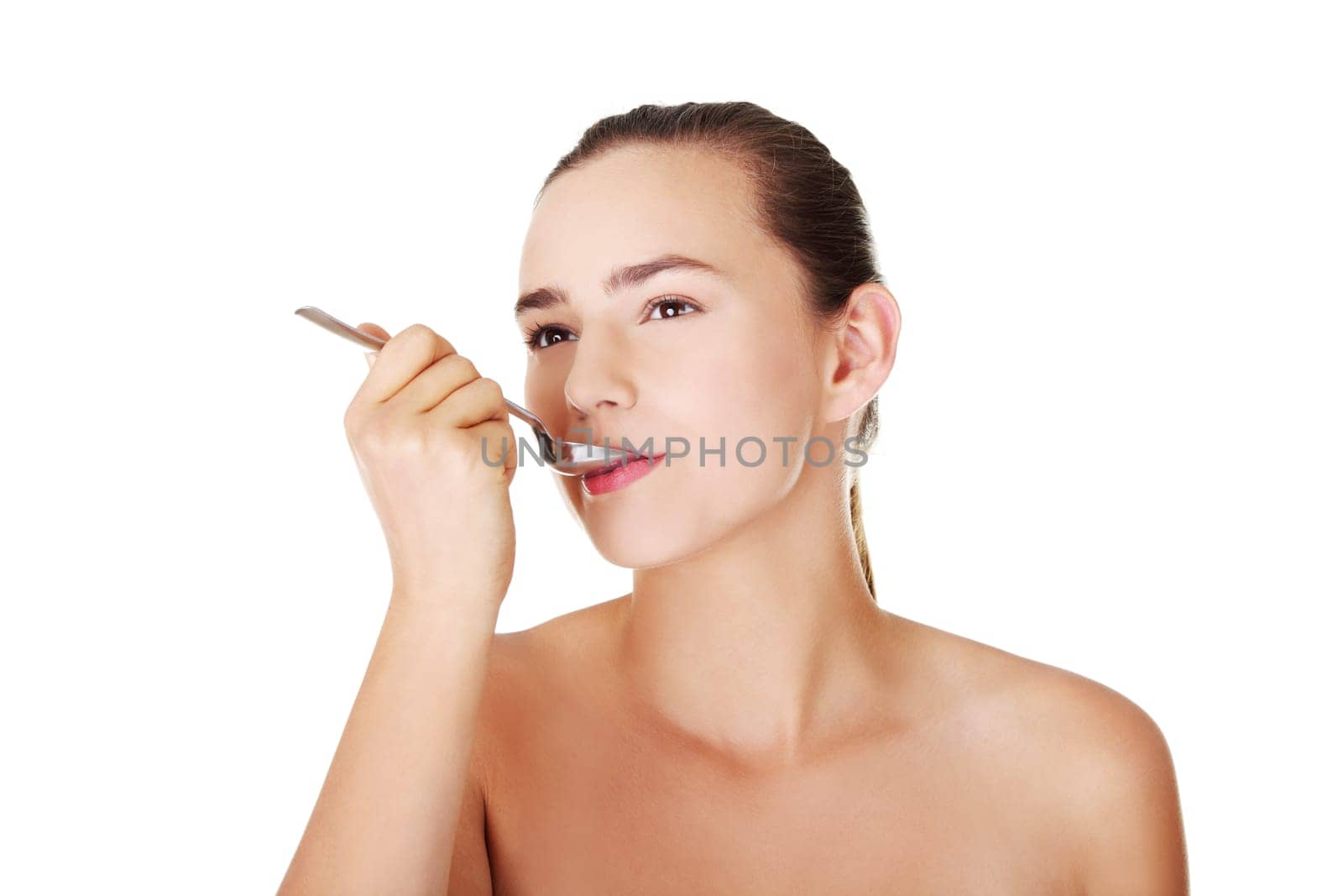 Teen girl with spoon in mouth. Isolated on white